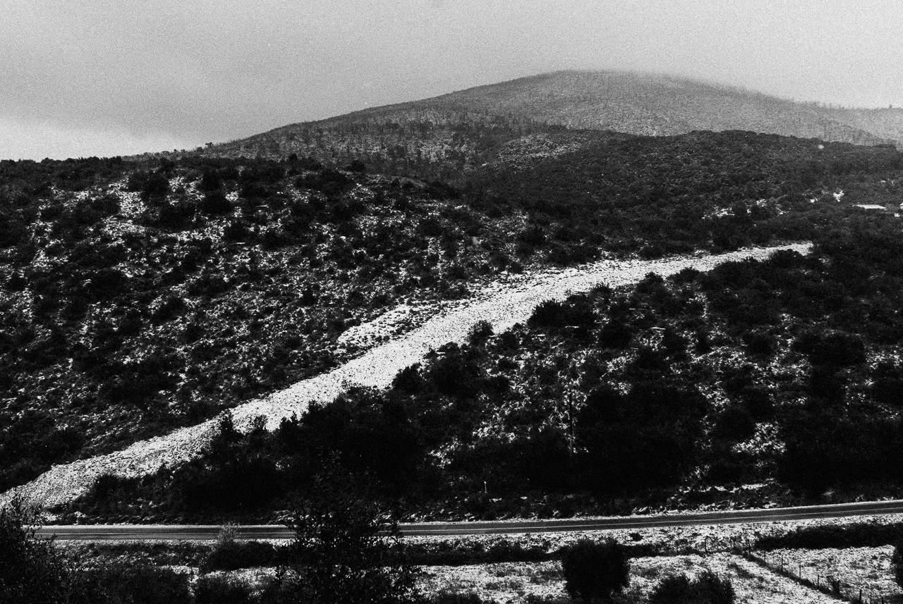 A close-up of a hand wearing multiple decorative rings against a blue background.