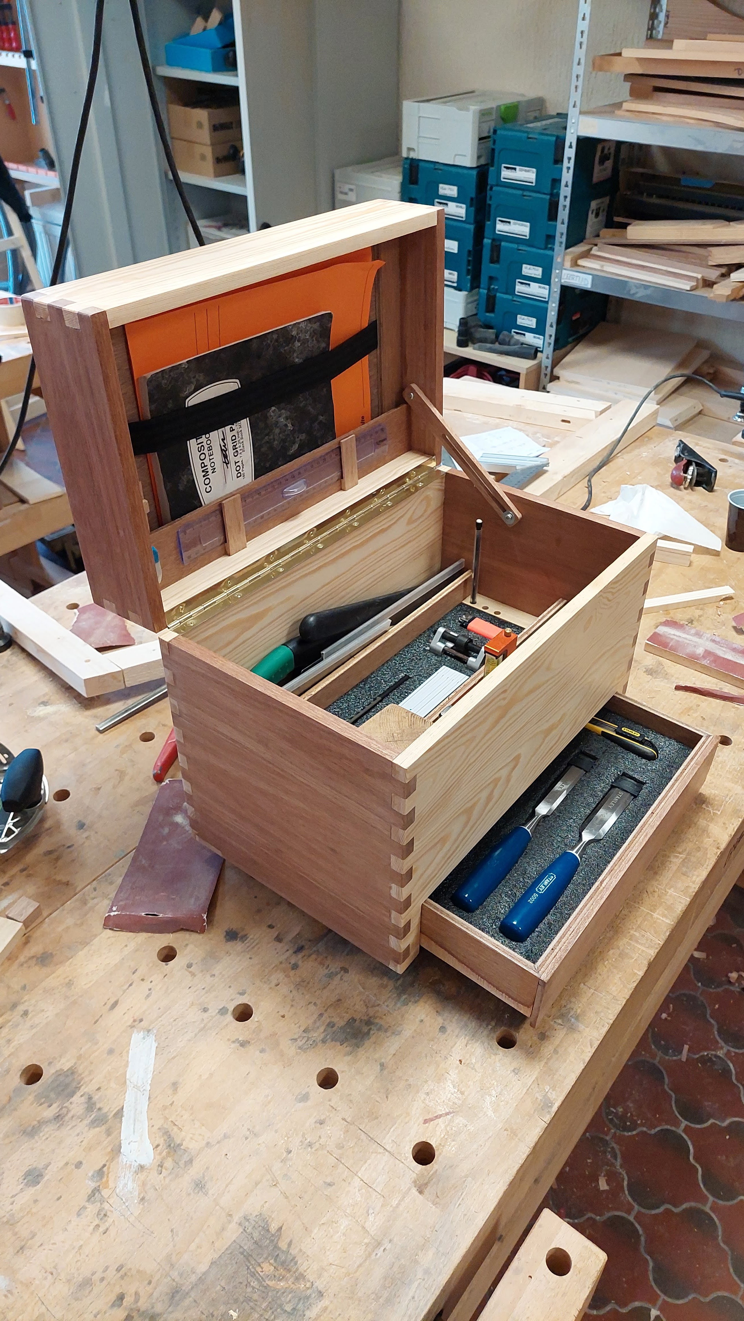 Een werkkoffer van een meubelmaker uit yellow pine en merantie hout met vingerlasverbinding aan de zijkanten en opbergruimtes voor hamers, beitels en ander gereedschap