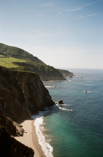 Coastal cliffside view with sandy beach and ocean below