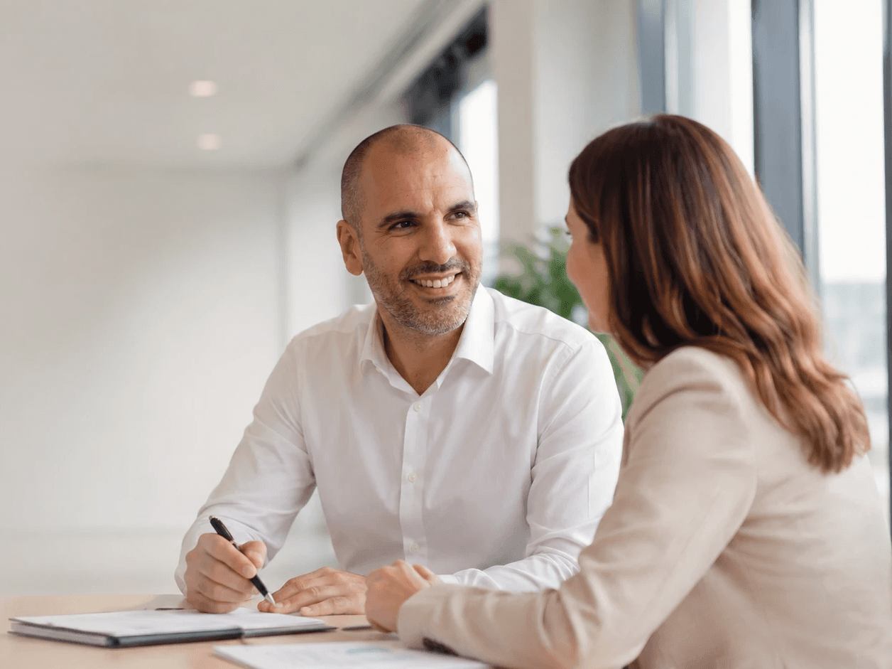 Échange professionnel entre un consultant AOY Conseil et une dirigeante de PME dans un bureau lumineux.