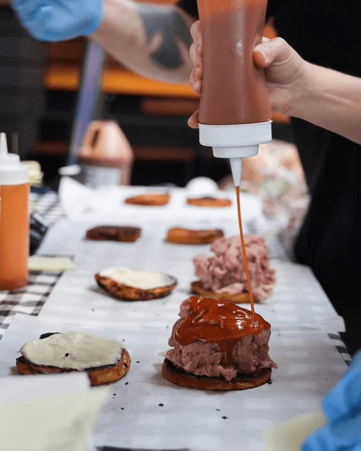Employee at Big Jim's Roast Beef saucing up the Super Beef, a local popular San Diego sandwich option located at Big Jim's Roast Beef in Pacific Beach, San Diego
