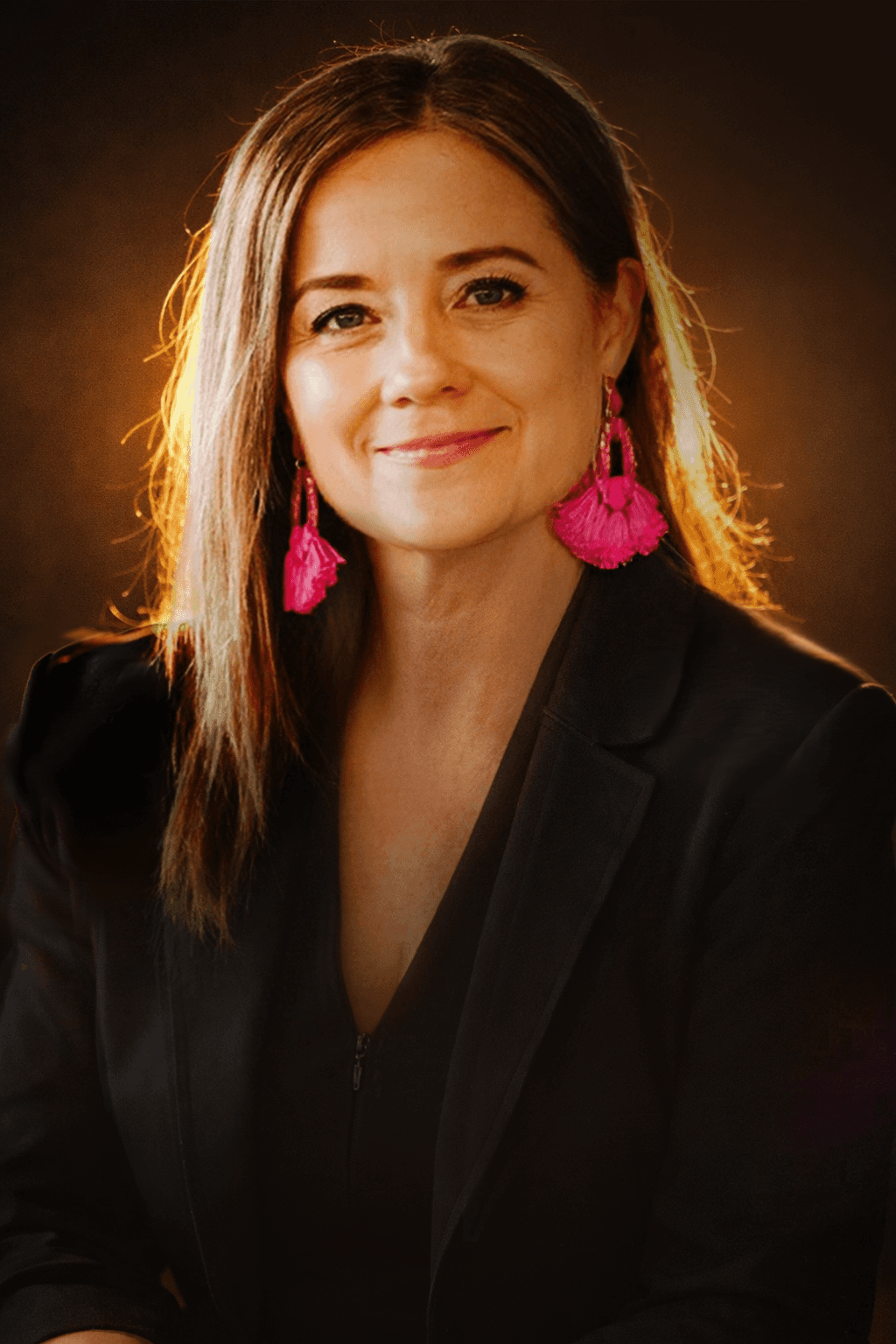 Cozy reading nook with sofa, chair, and plants inside a glass cabin with mountain forest views.