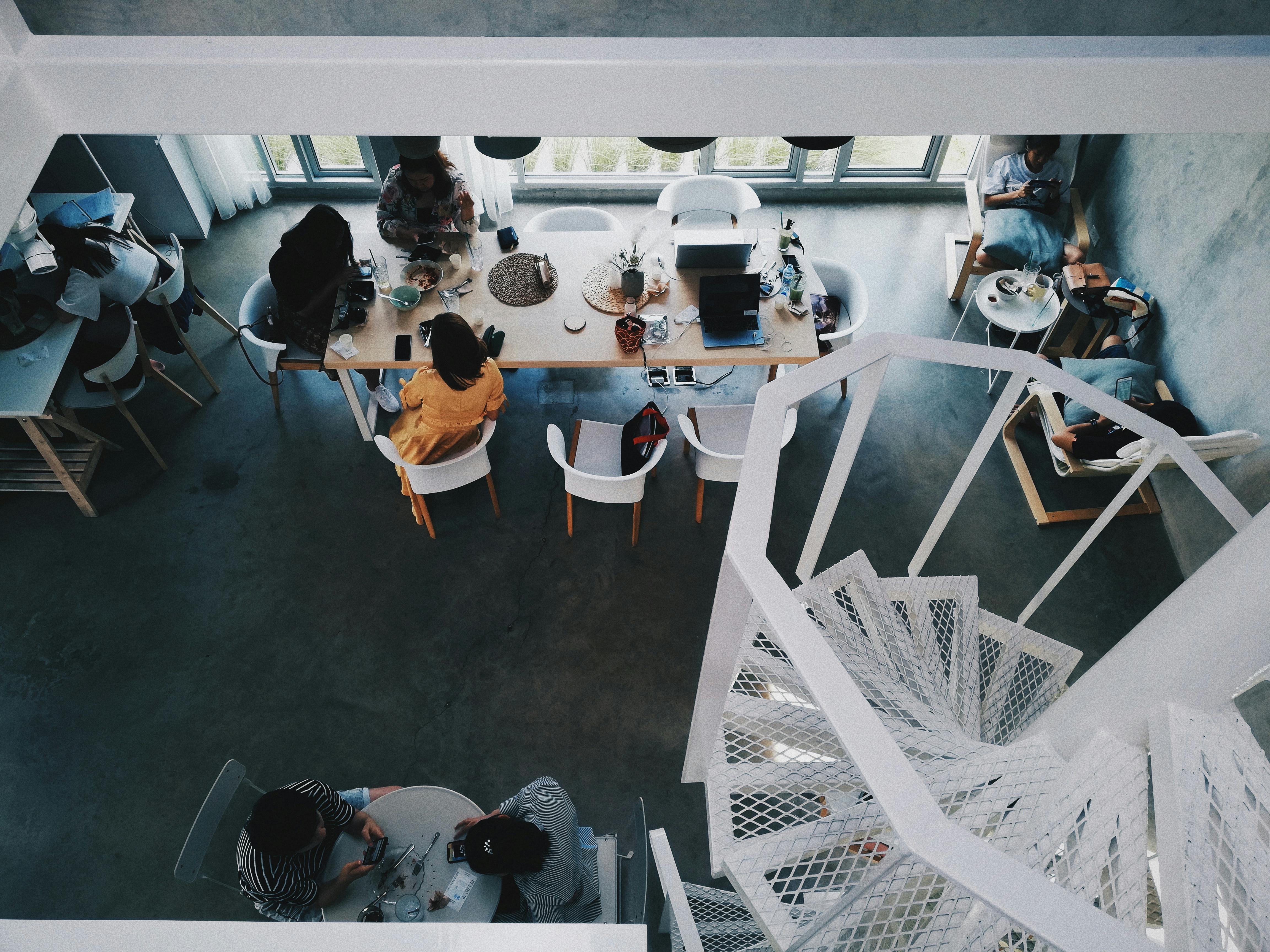 Vista dall’alto di open space startup: collaborazione in coworking su casi reali