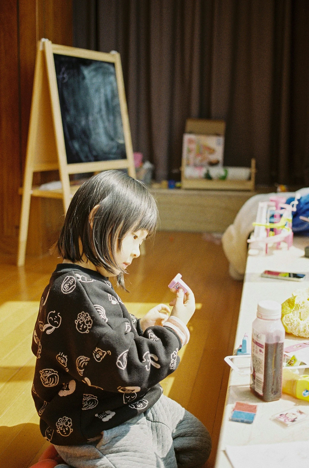 Little girl exploring creative materials in a bright and safe preschool classroom