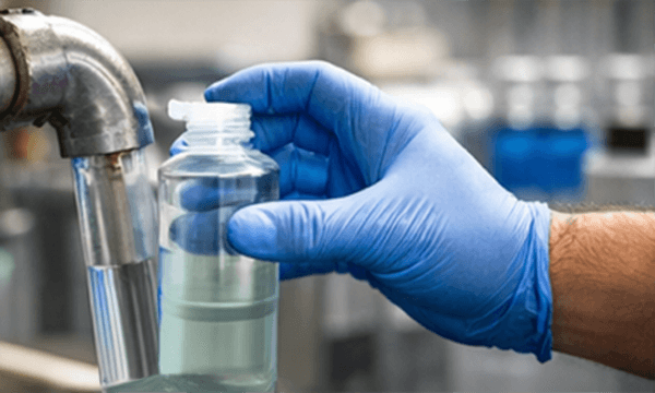 hand holding bottle testing water