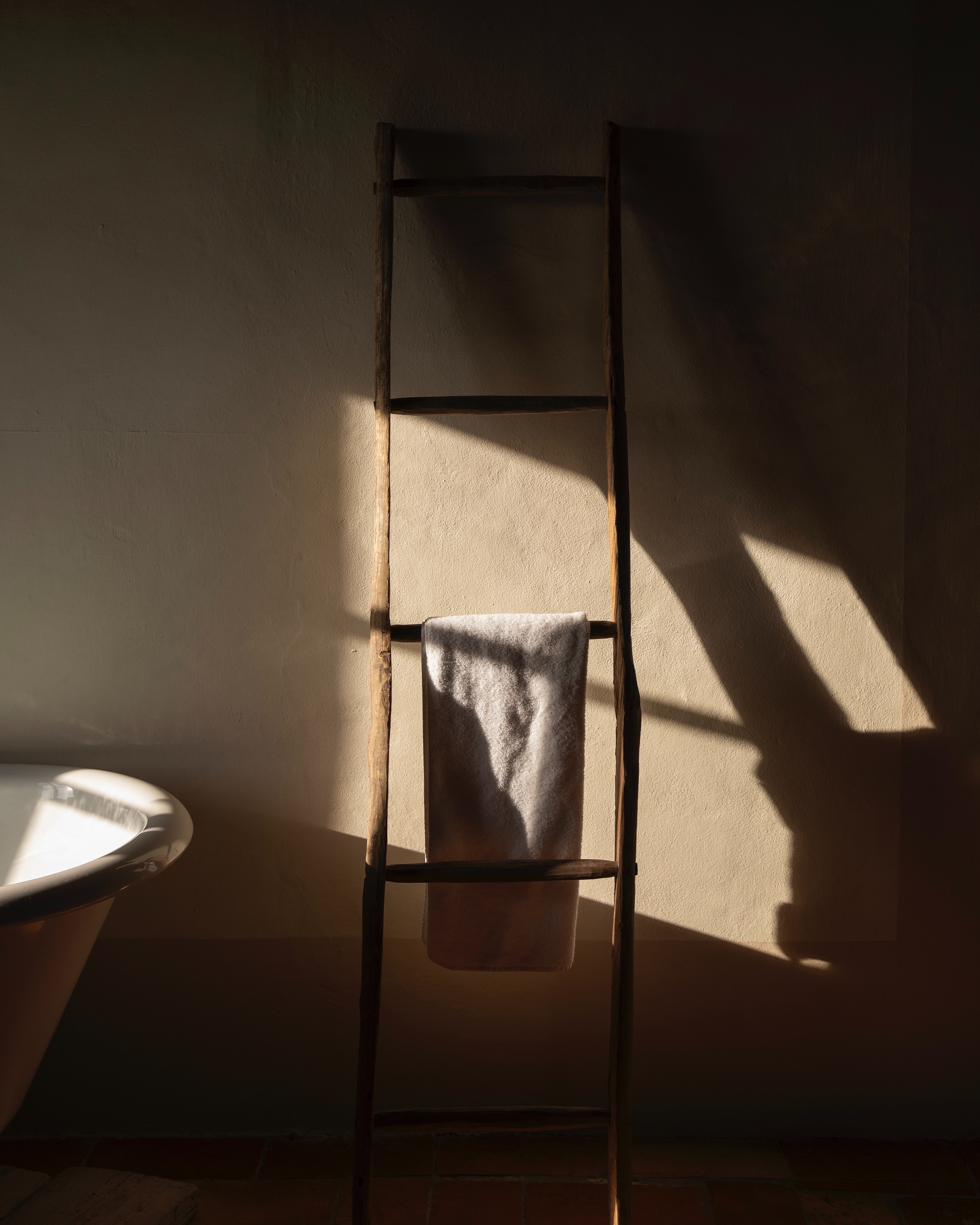 A wooden bathroom ladder against the wall