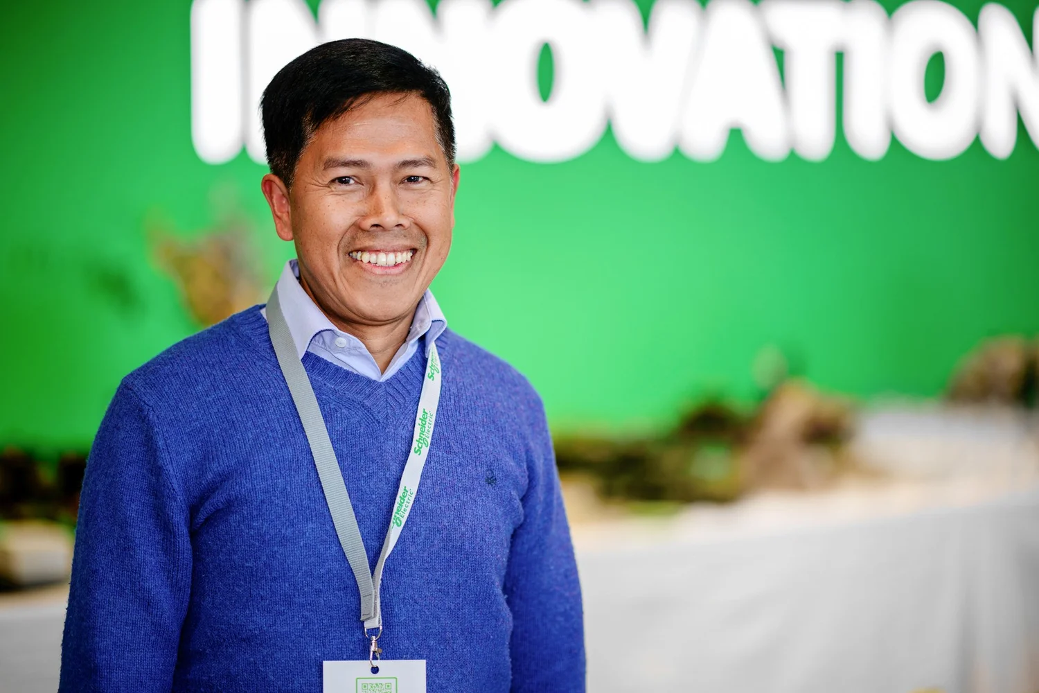 Portrait d'un des participants devant la signalétique schneider Innovation Hub