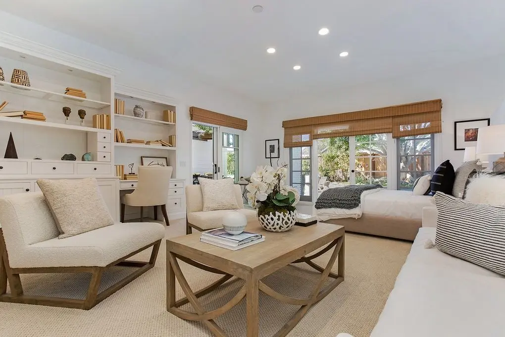 'Port Streets Remodel' family room with built-in shelving, desk area, comfortable seating, and a view to the garden.