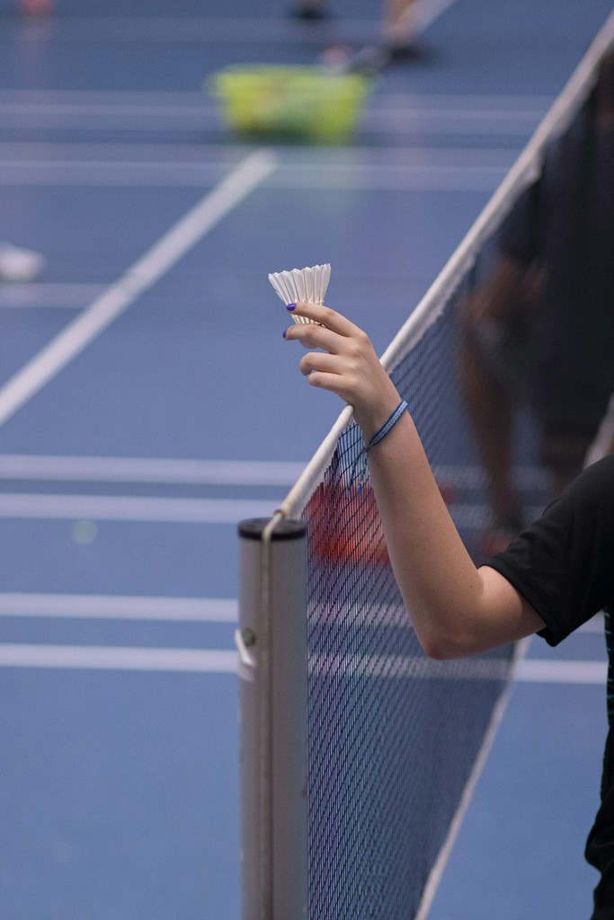 person holding white shuttlecock