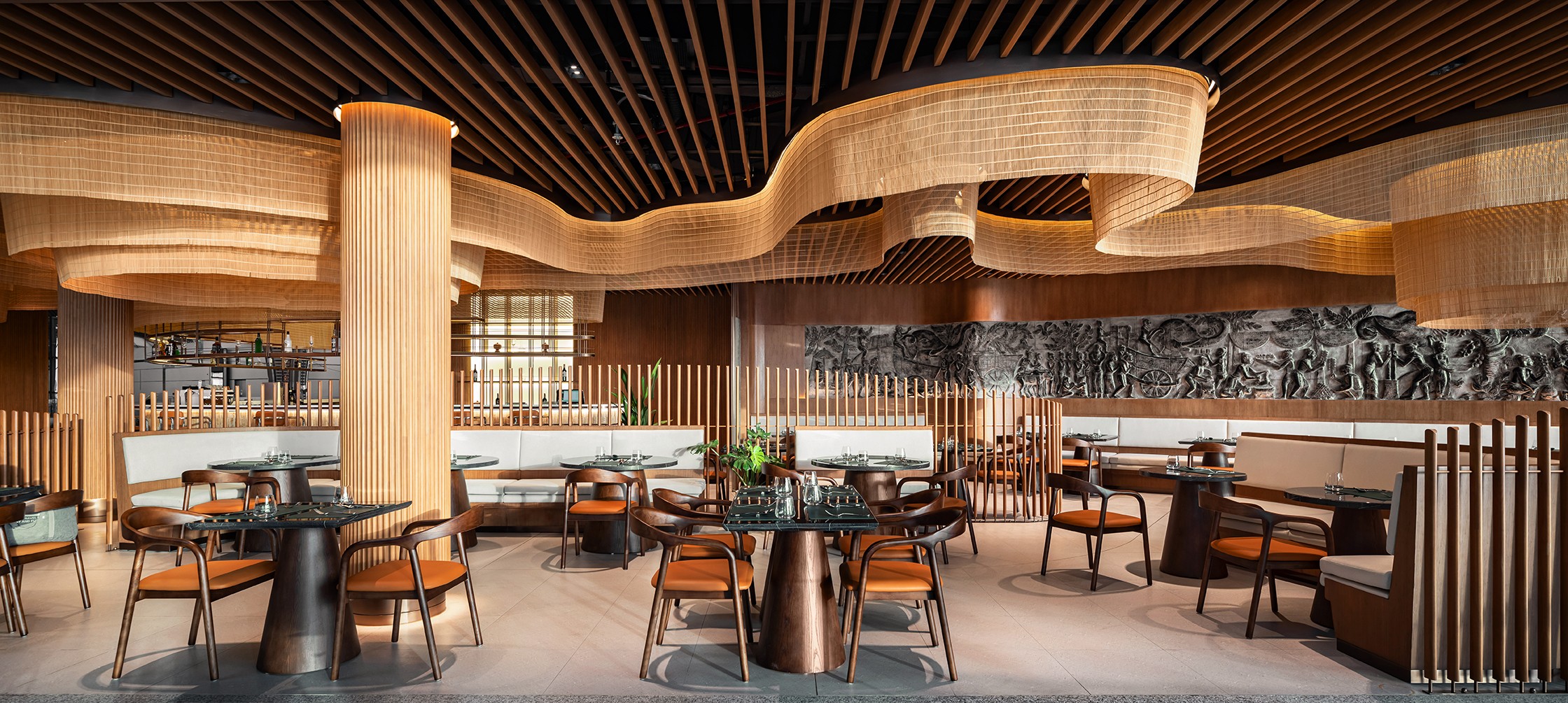 Open dining area with woven ceiling forms, timber screens, and cultural wall detailing at Techo International Airport