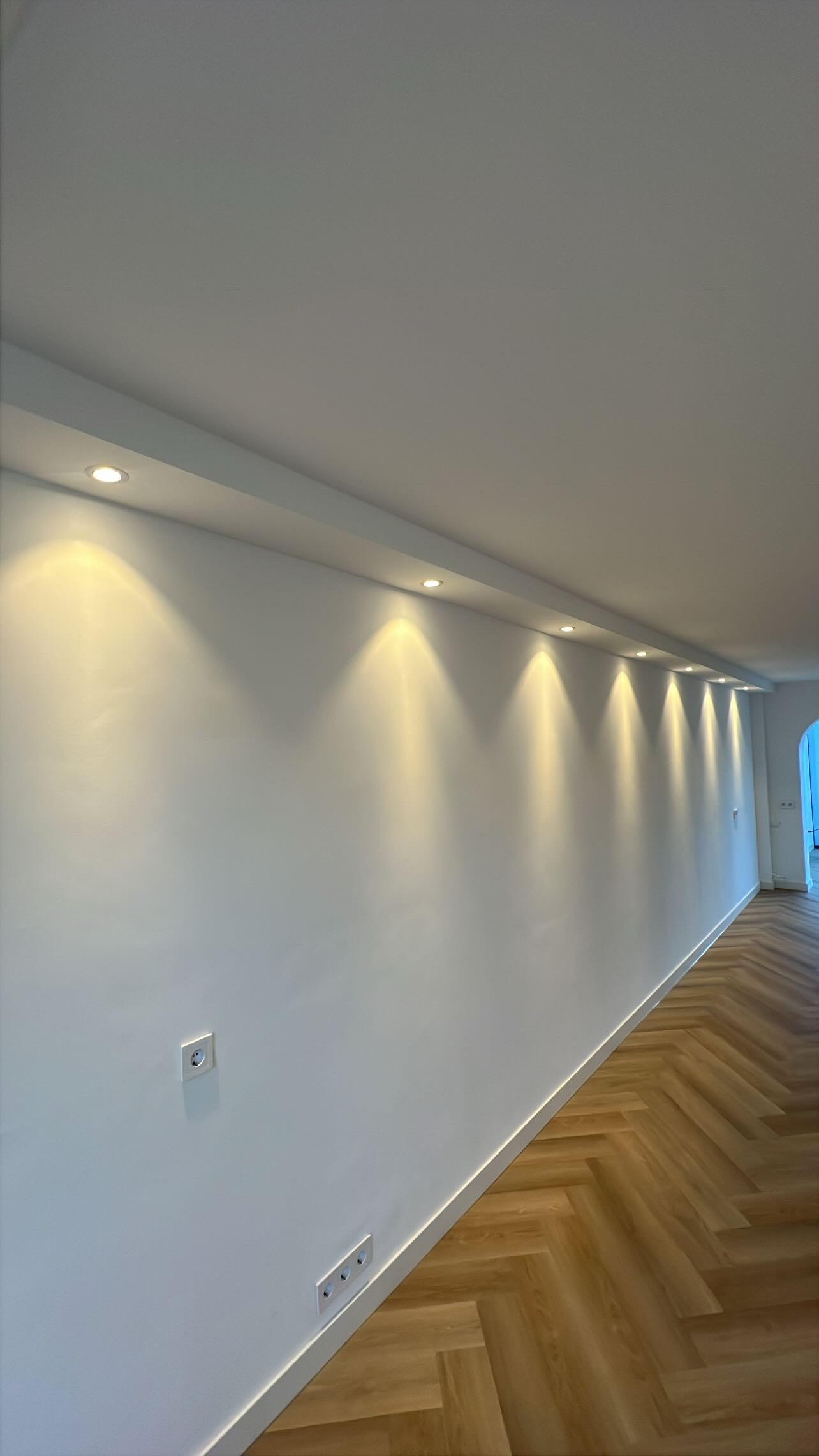 Modern glass buildings with illuminated facades and trees on a rainy day