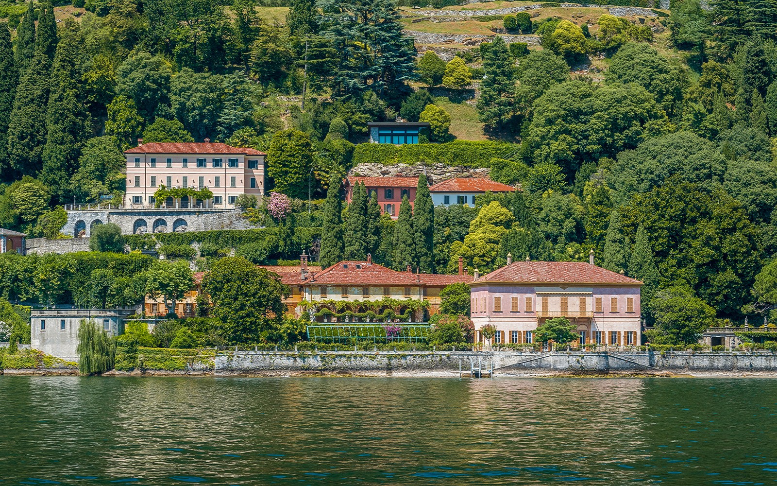 Elegant villas surrounded by lush greenery on the shores of Lake Como during a public tour.