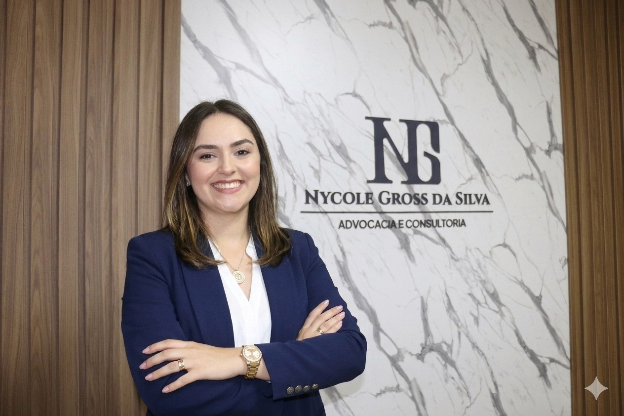 Confident woman in a tan suit holding a resume in a bright office, with colleagues working in the background.