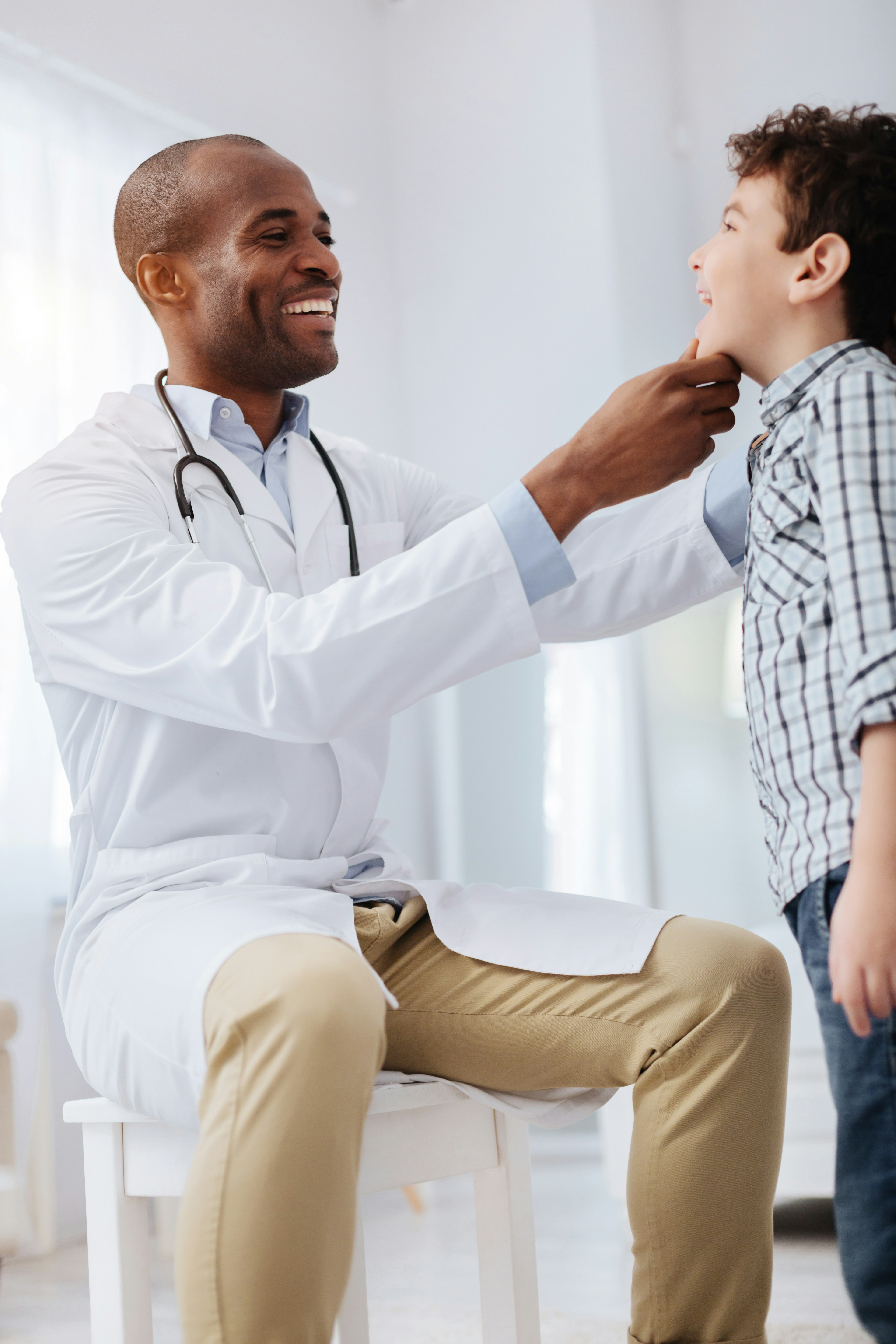 A pregnant patient smiling while seated next to a provider