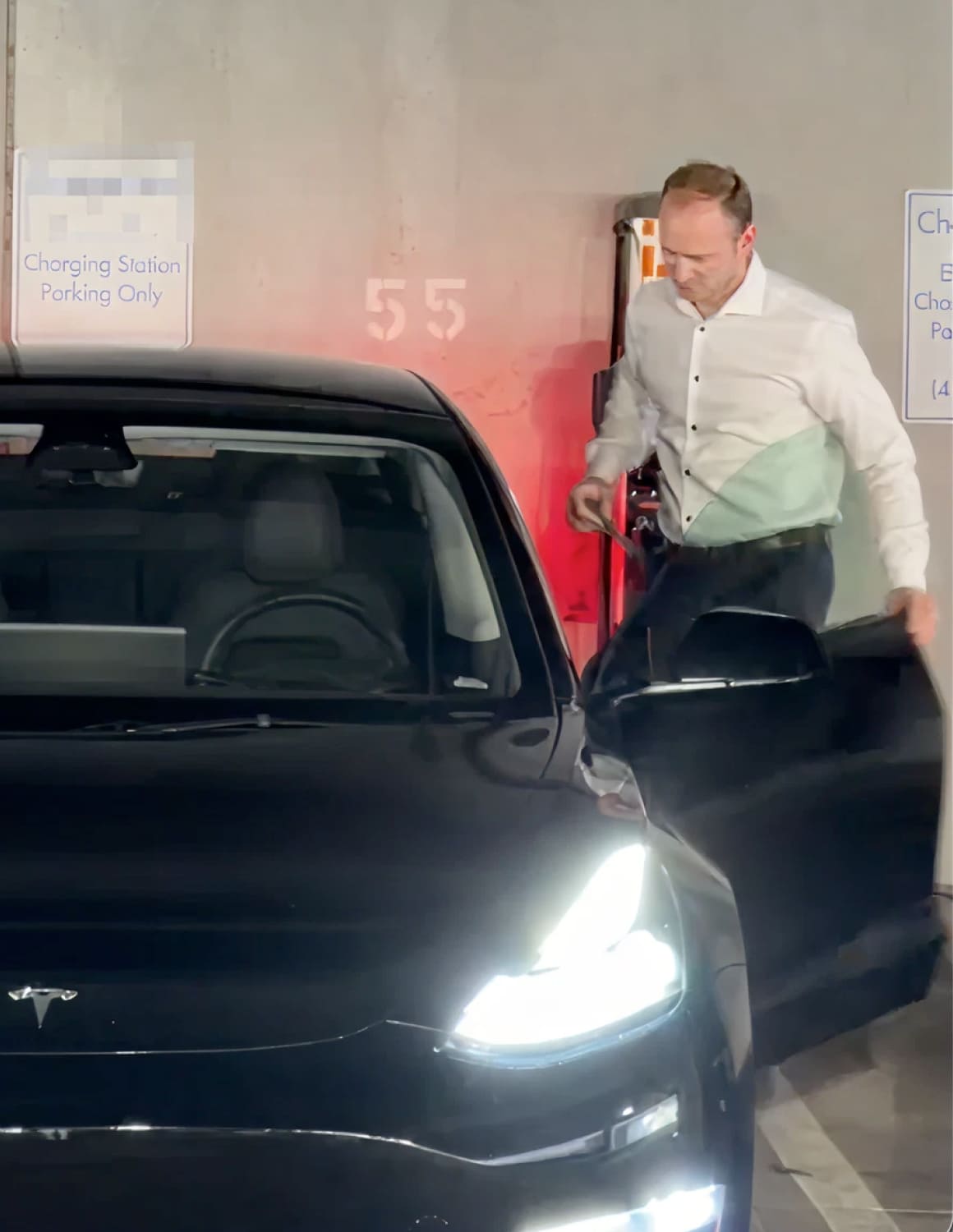 Inside his apartment building's garage, Dan enters his Tesla Model 3 