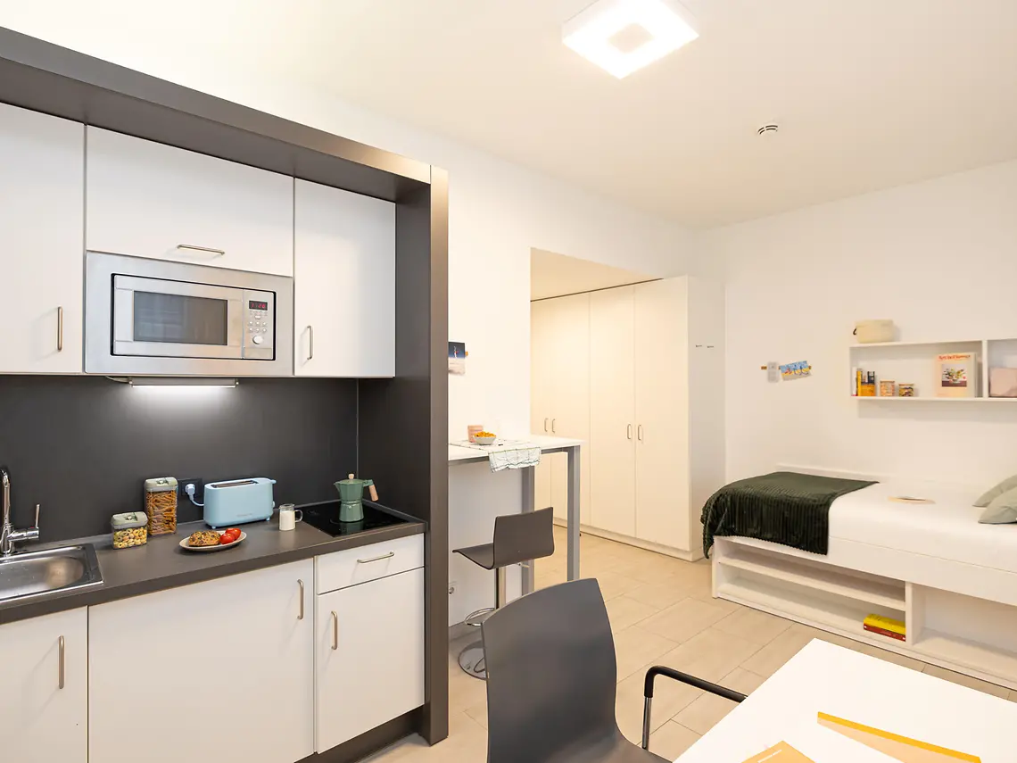 Private student studio in Darmstadt with kitchenette, bed and dining area