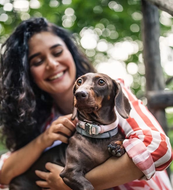 A weiner dog and its owner smiling