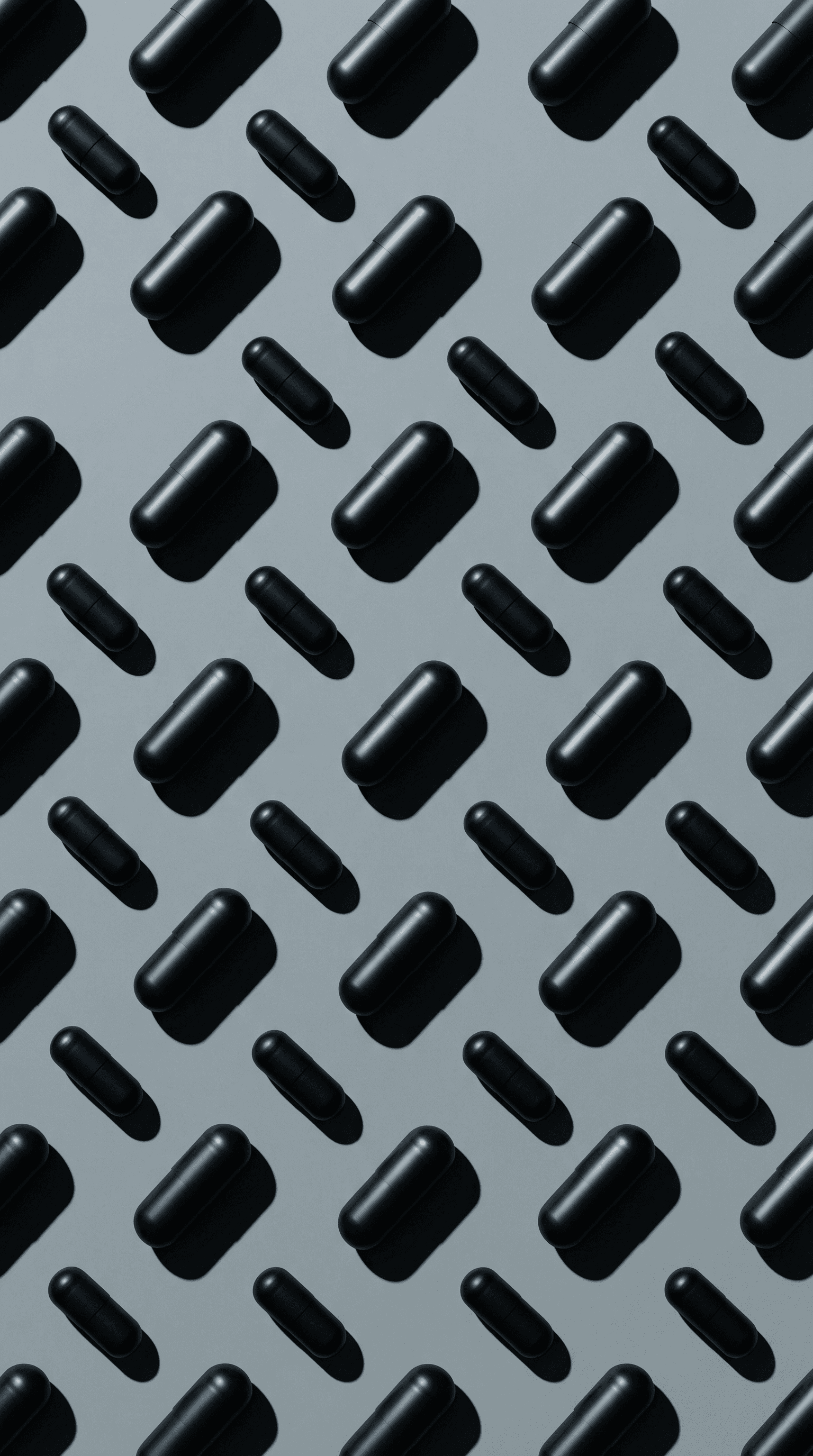 Black capsules arranged in a diagonal pattern on a cool grey background