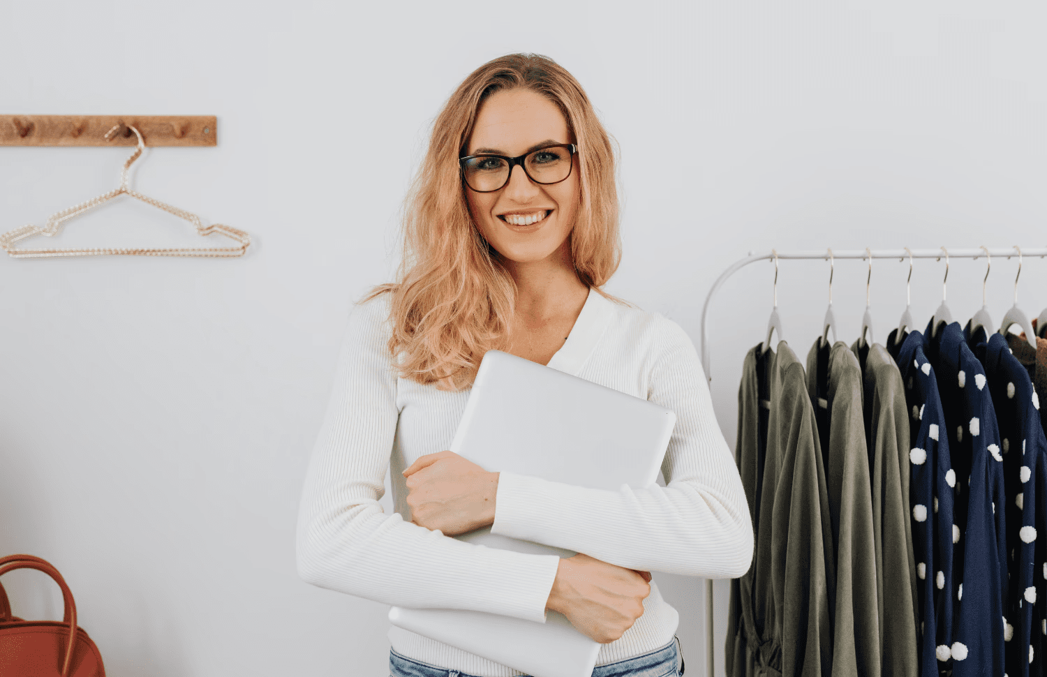 Sandra Kleiner, Geschäftsführerin Modehaus Kleiner klammert sich an ihrem Laptop fest mit Freude im Gesicht