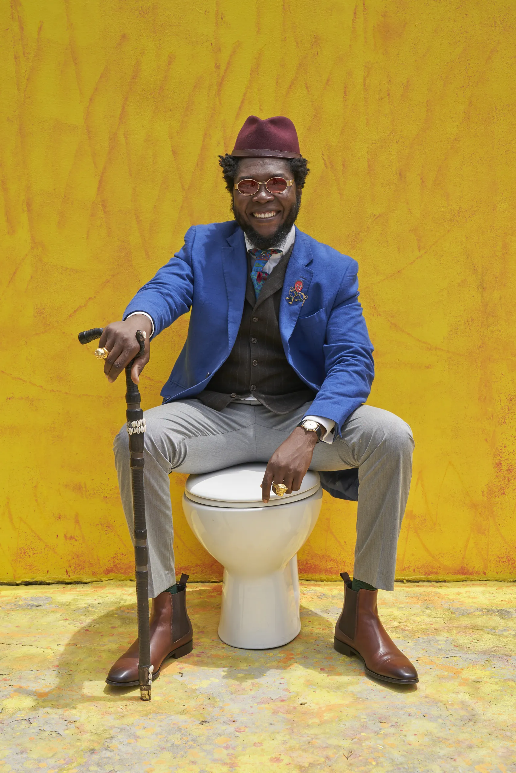 Portrait of a person in colorful traditional attire seated on a stool
