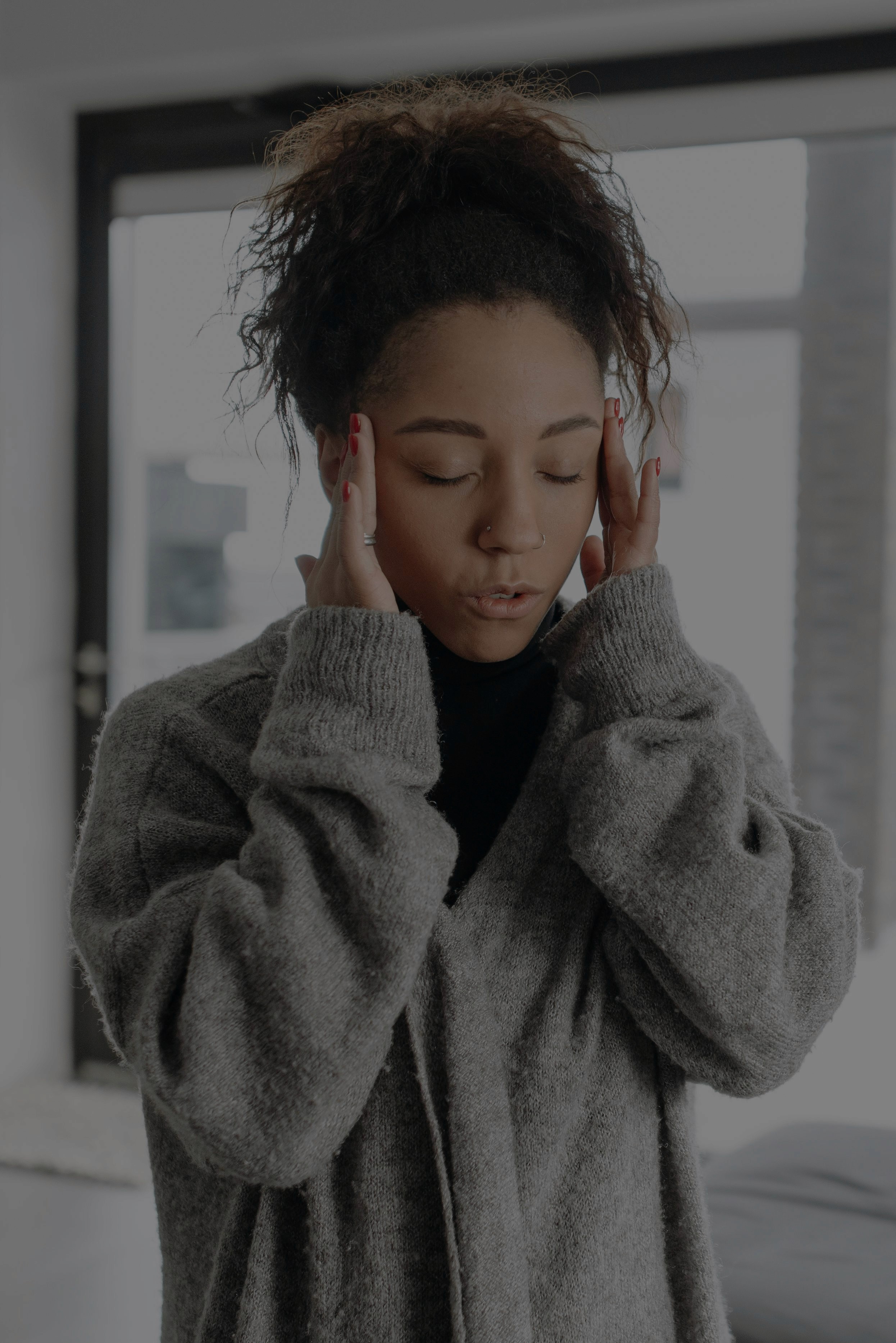 Woman with hands pressed to her temples representing the distress of intrusive thoughts and OCD anxiety