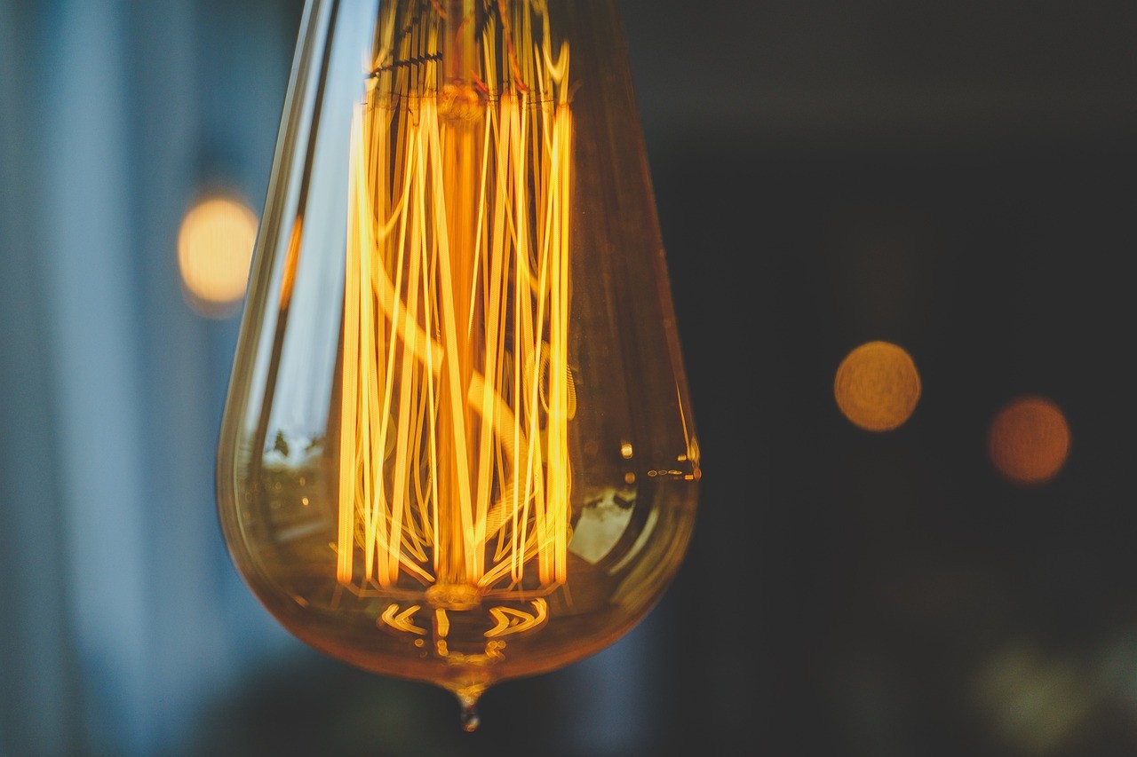 A close-up of an illuminated Edison-style light bulb.