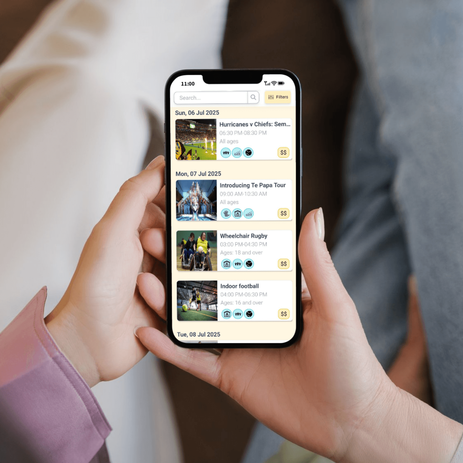 Two people holding a phone looking at a list of sports events