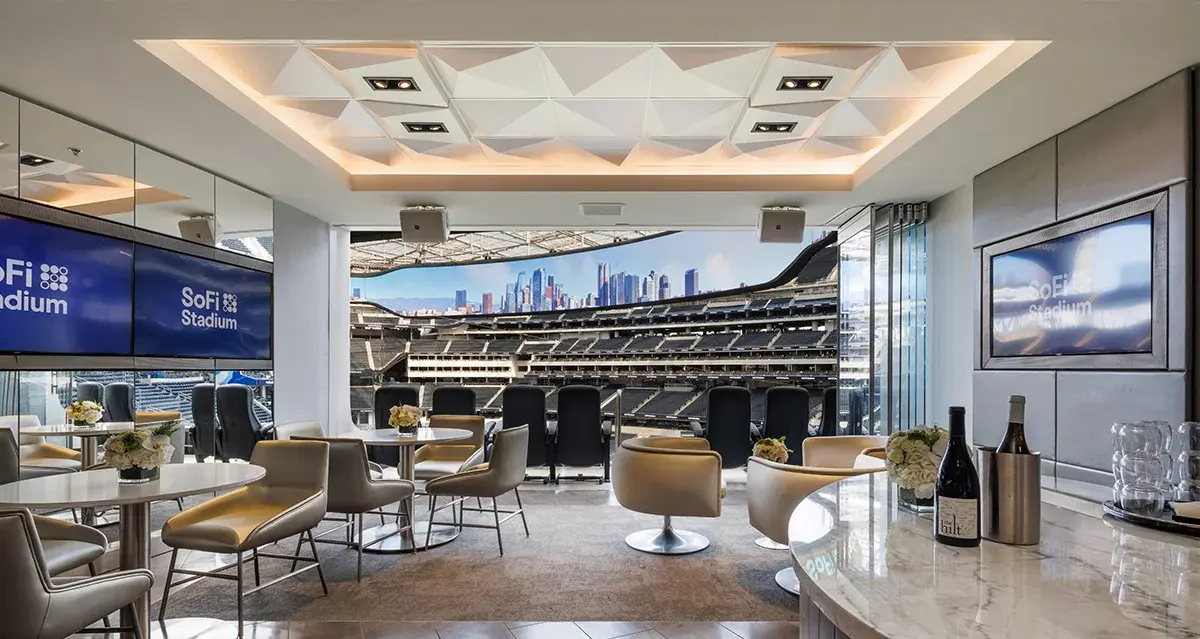 Luxury VIP suite at SoFi Stadium overlooking the field, featuring modern seating, SoFi branding, and premium hospitality setup for guests.