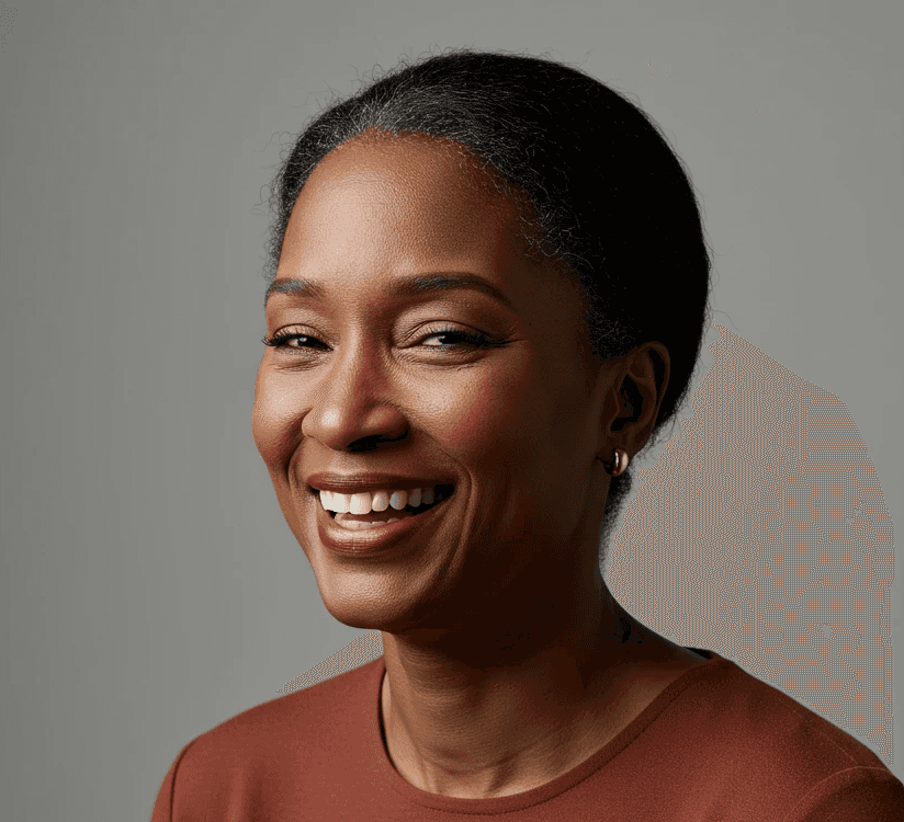 Smiling woman with brown skin, short dark hair, and small gold earrings. She wears a brown shirt and looks happy.