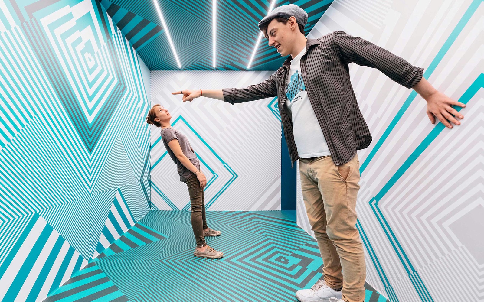 Pengunjung yang berinteraksi di ruangan ilusi optik di Museum of Illusions Vienna.