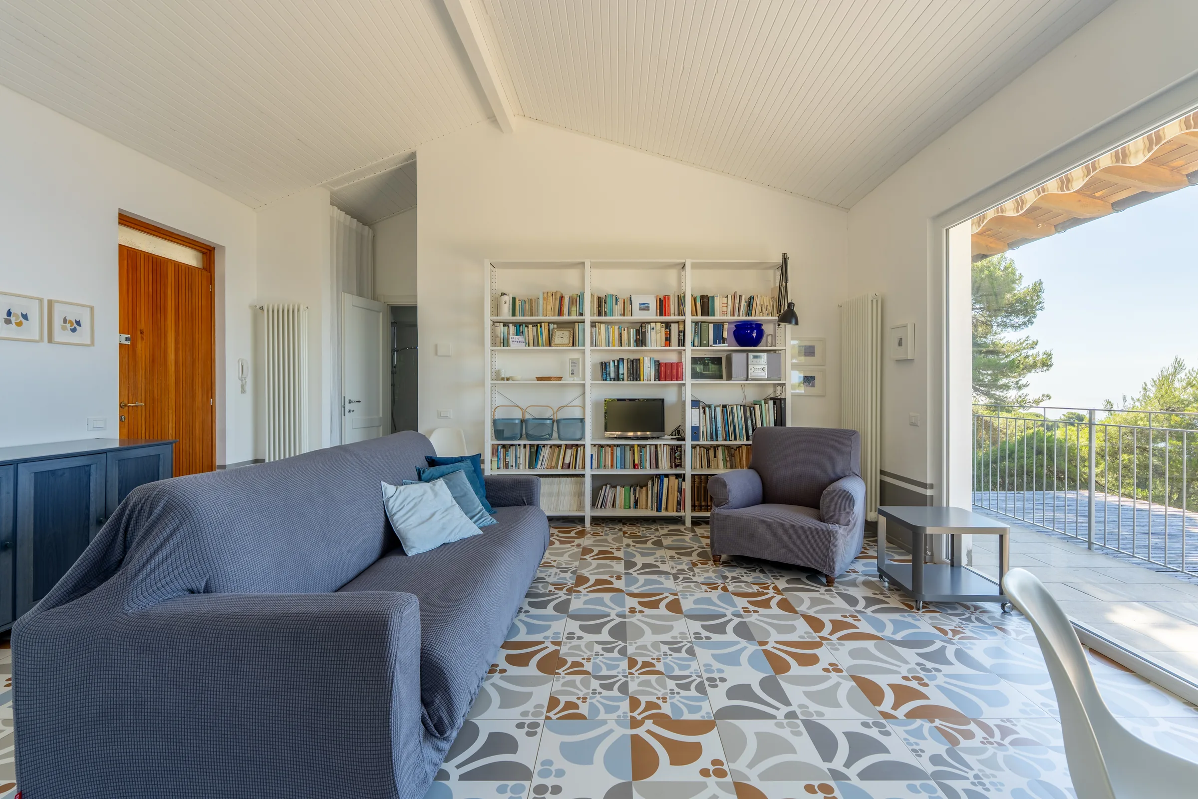 Living room opening towards a sea view balcony — Province of Imperia, Italy. Photography by Yunes Calore.