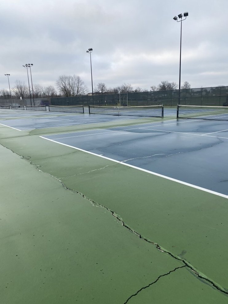 Tennis court showing signs of wear and tear