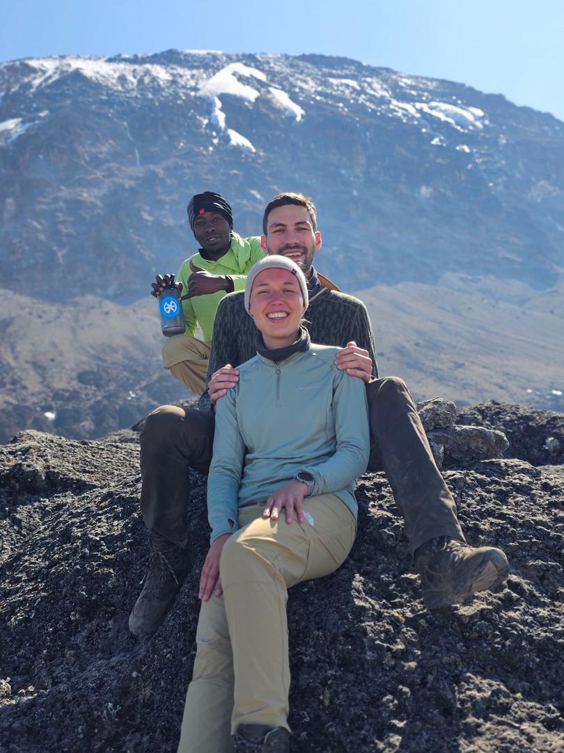 Lone traveler walking across golden dunes in AlUla desert, leaving footprints under clear morning light.
