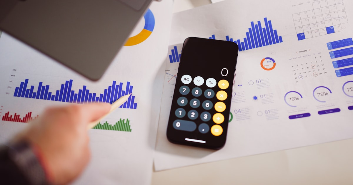 A calculator and laptop set up for managing a budget with an AI money app