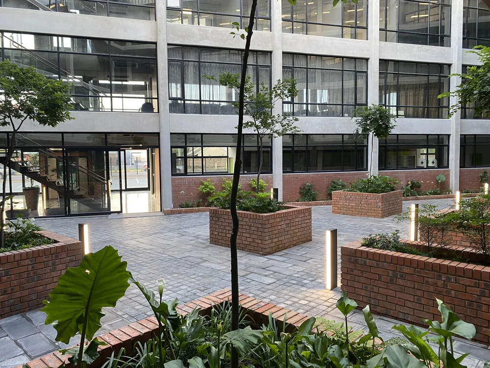 Modern black minimalist house with sharp geometric lines with warm light at dusk.