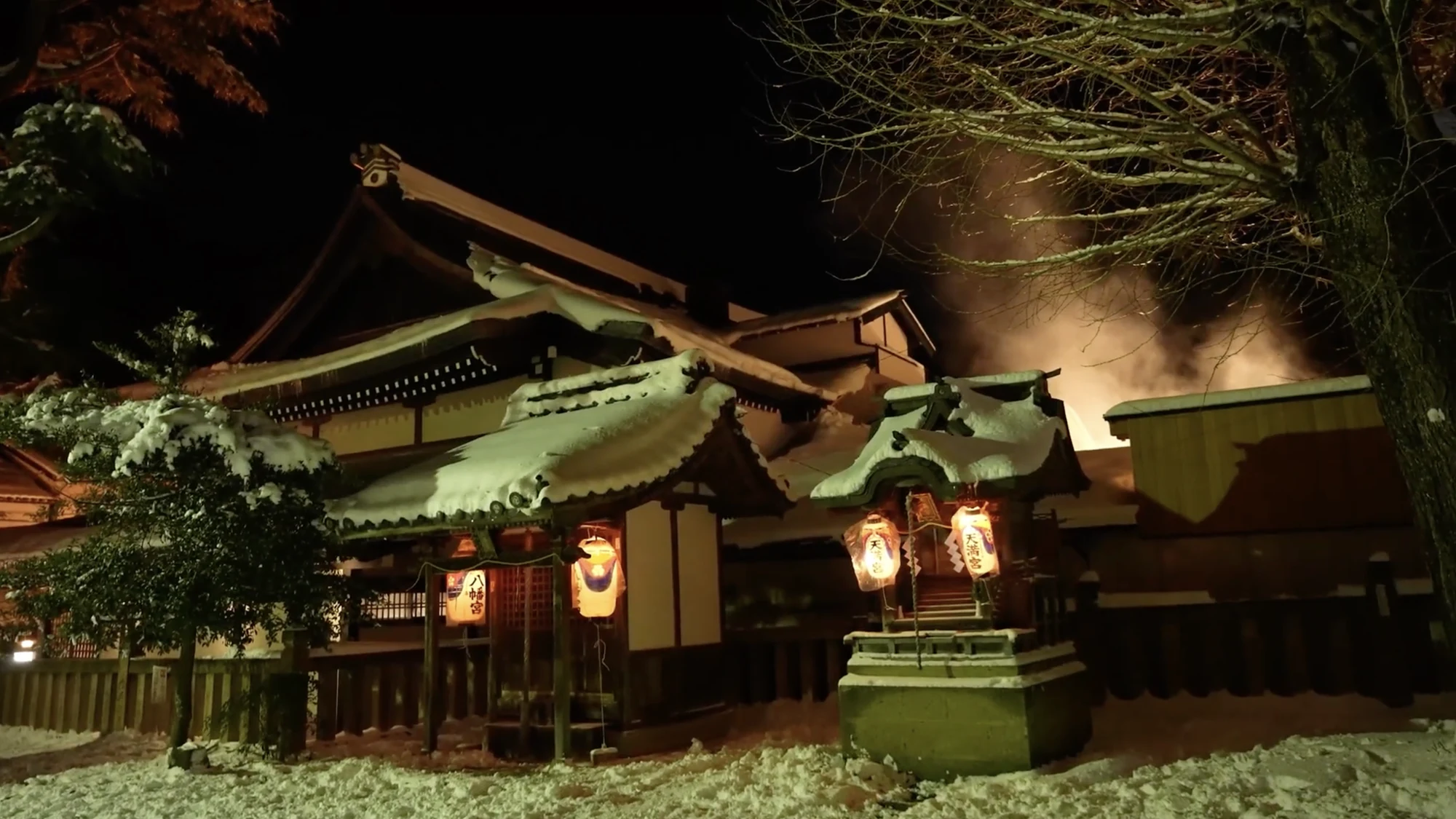 Shisho Shrine in Kinosaki lit by paired paper lanterns at night.