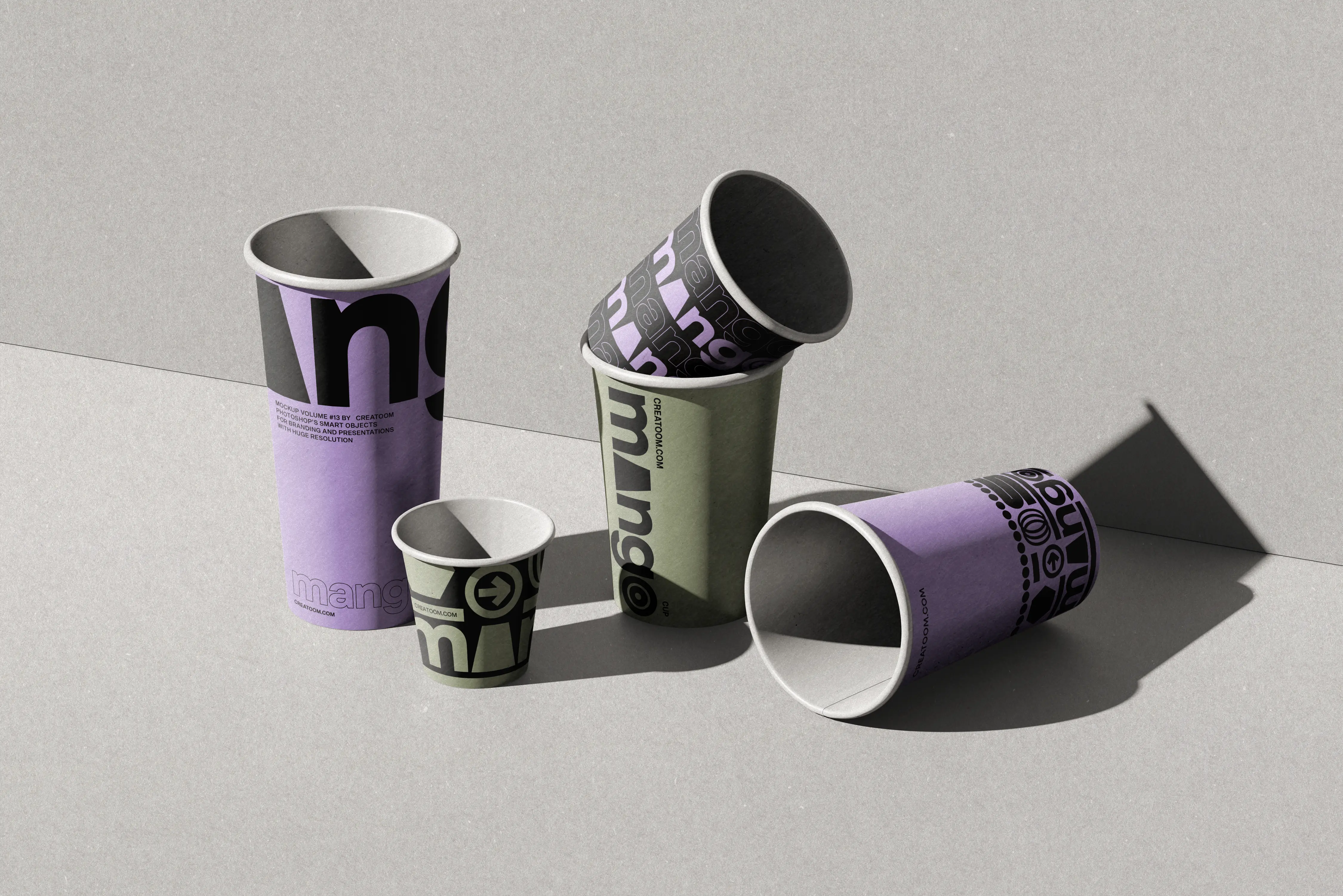 Group of printed cups and one small cup scattered on a grey surface
