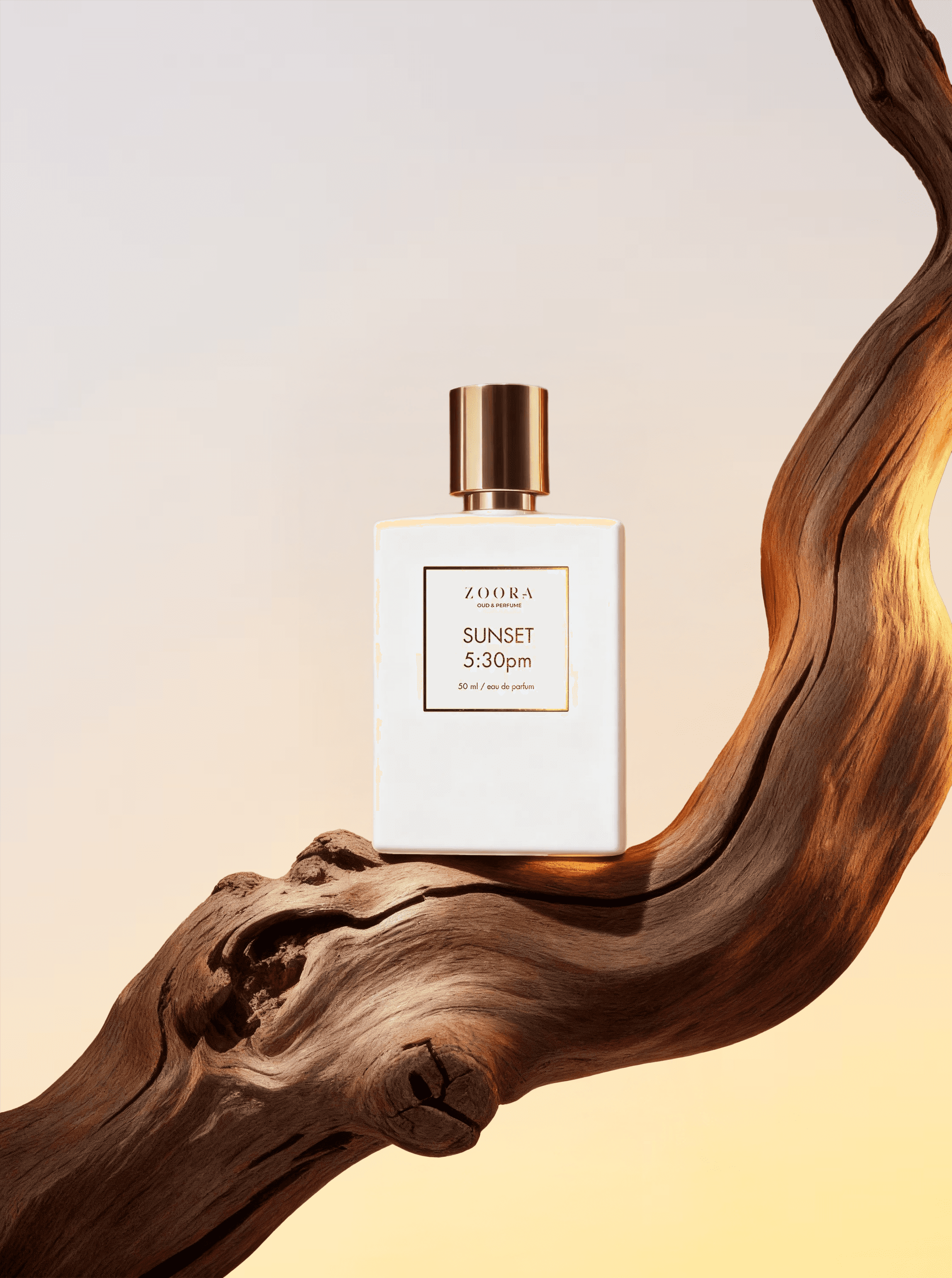 Perfume bottle resting on a curved wooden branch in a sunset background