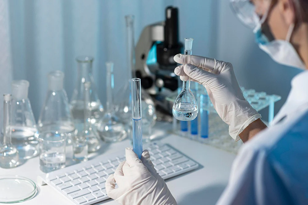技術人員於 ISO 潔淨室內操作生物安全櫃及移液器，展示專業實驗室無塵工程與潔淨空間設計。