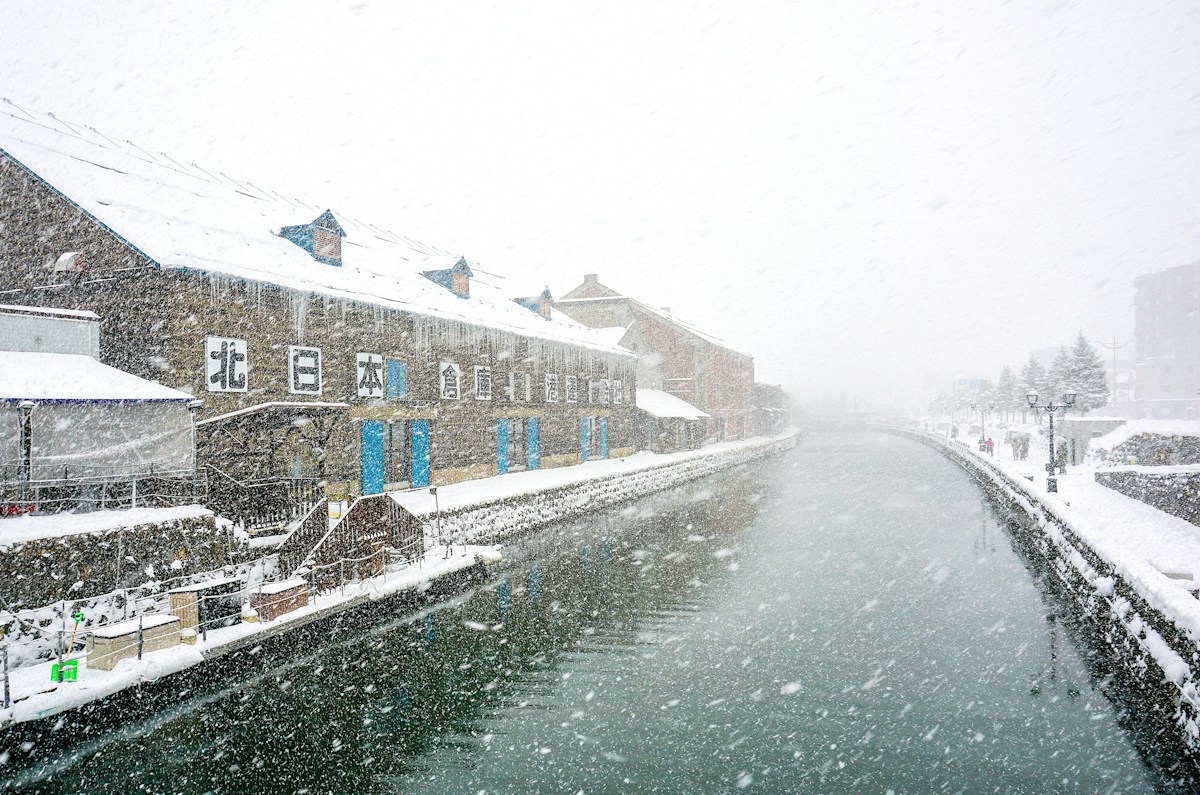 Snow falling over a historic canal in Hokkaido