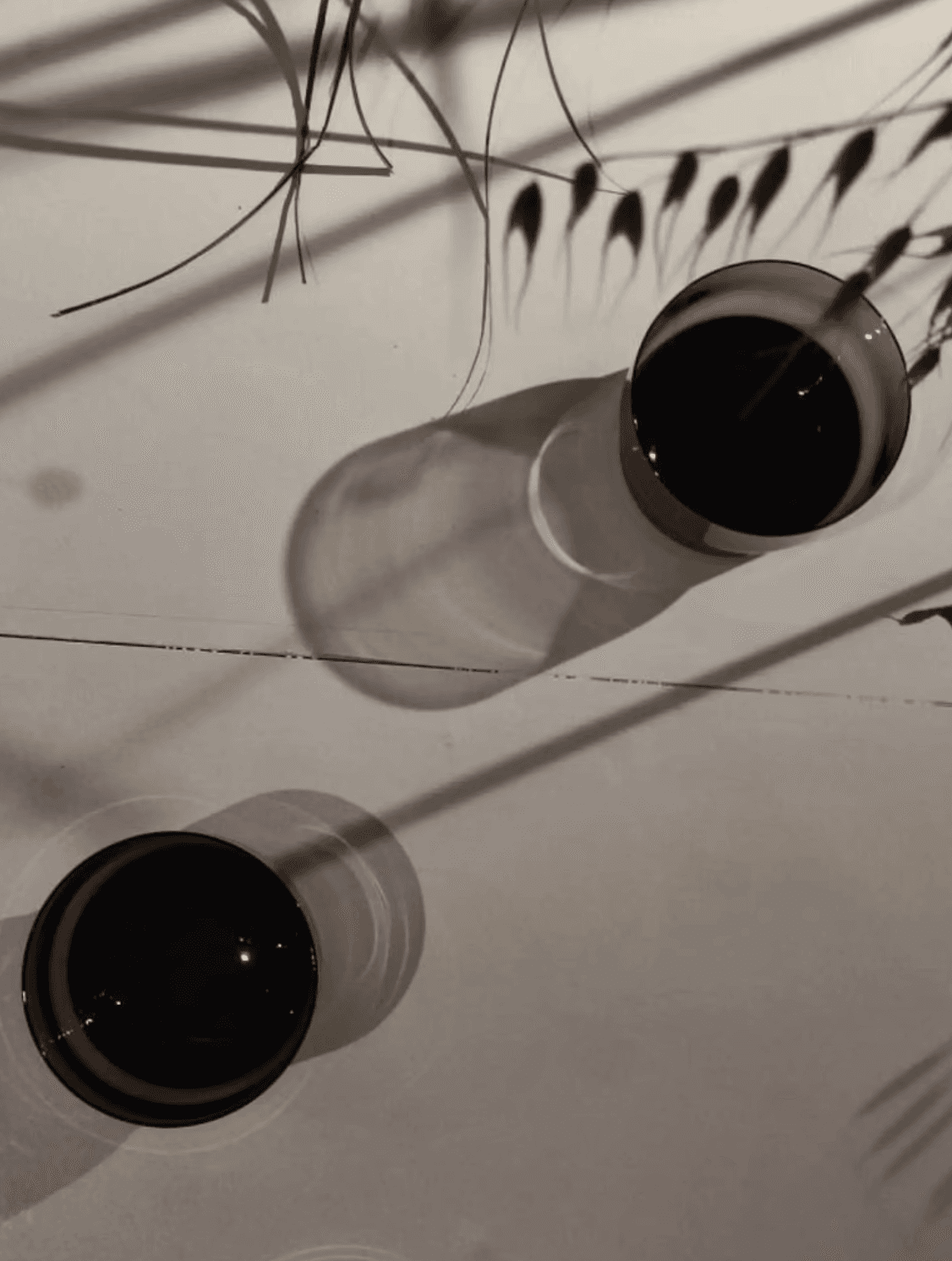 Arreglo floral con gloriosas rojas, aves del paraíso y hortensias verdes sobre una barra de bar iluminada por un letrero de neón con la palabra ‘Meta’, al fondo botellas y copas tras una persiana de madera.