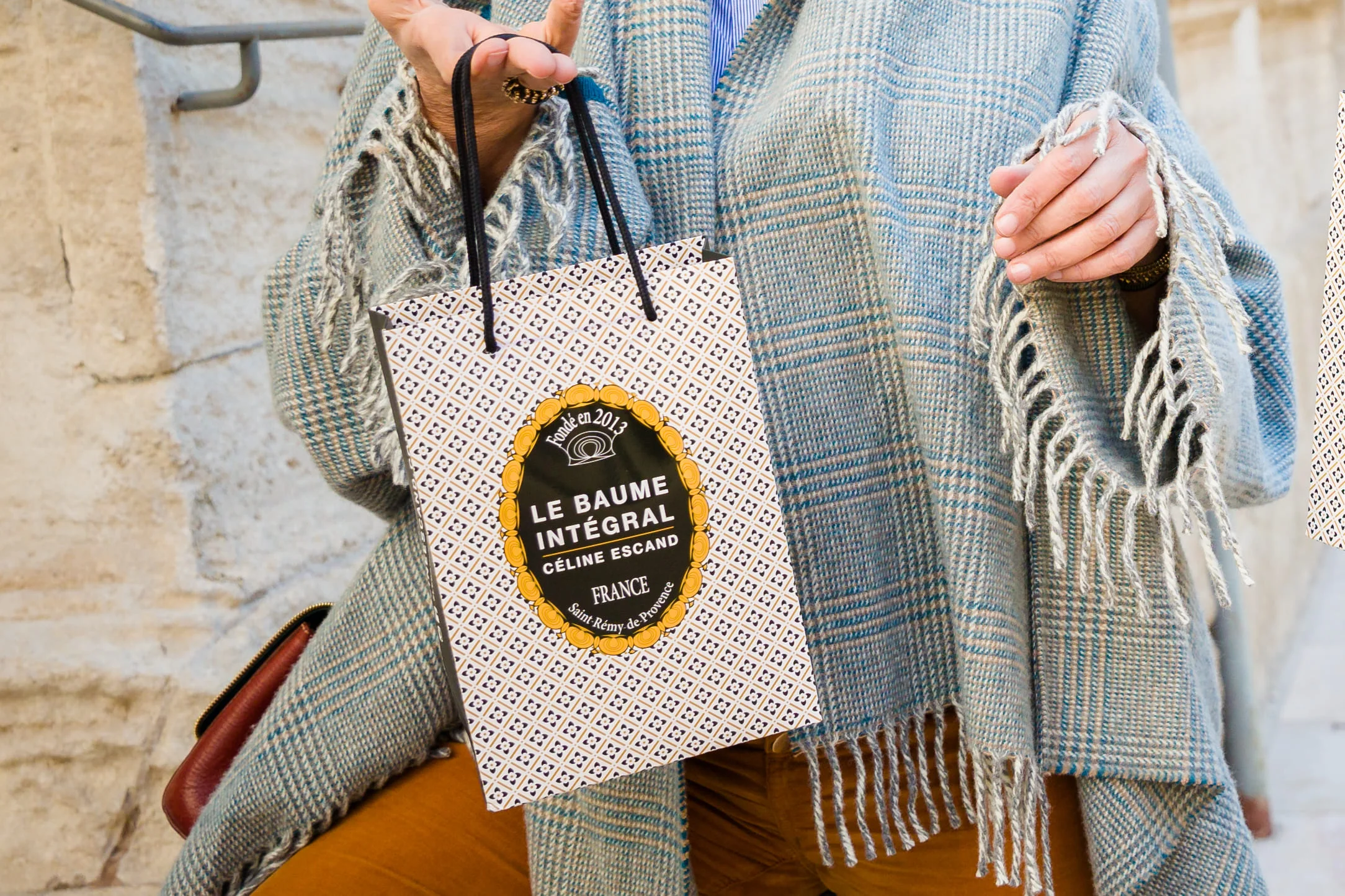 sac de la marque le baume intégral tenu à la main, avec logo visible