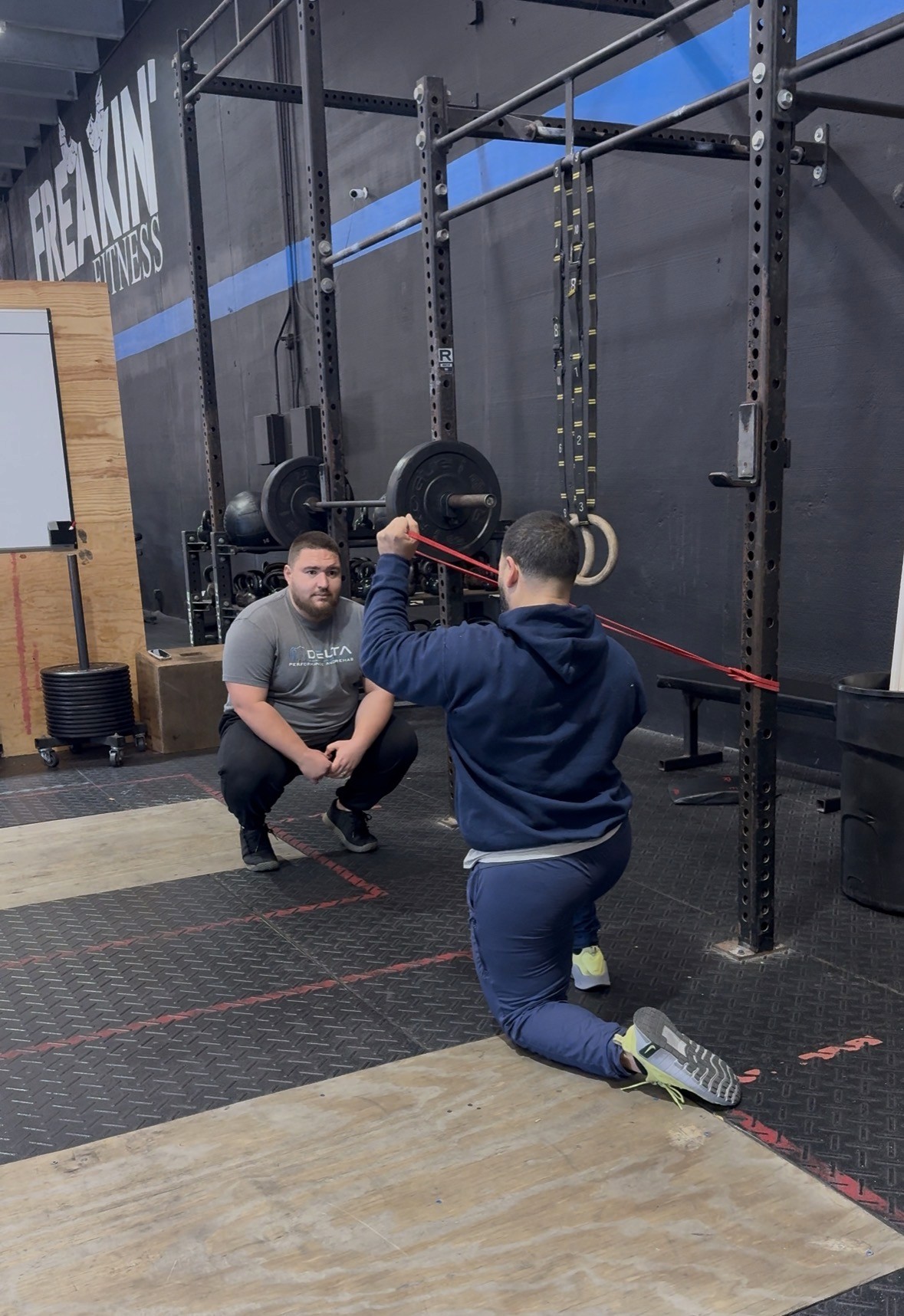 DPT instructing athlete how to perform shoulder exercise