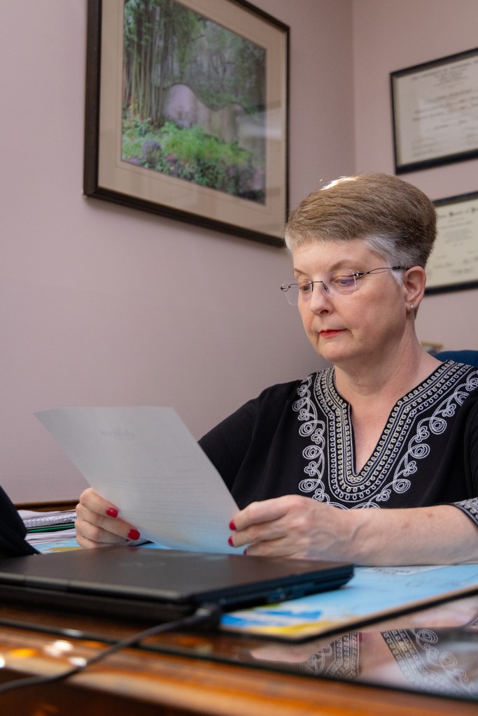 Pediatrician woman reading printed charts in her office.