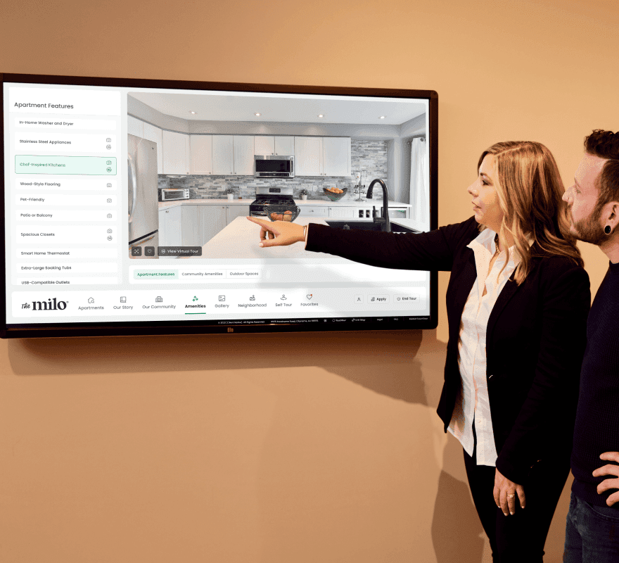 Woman giving a tour using an interactive touch screen.