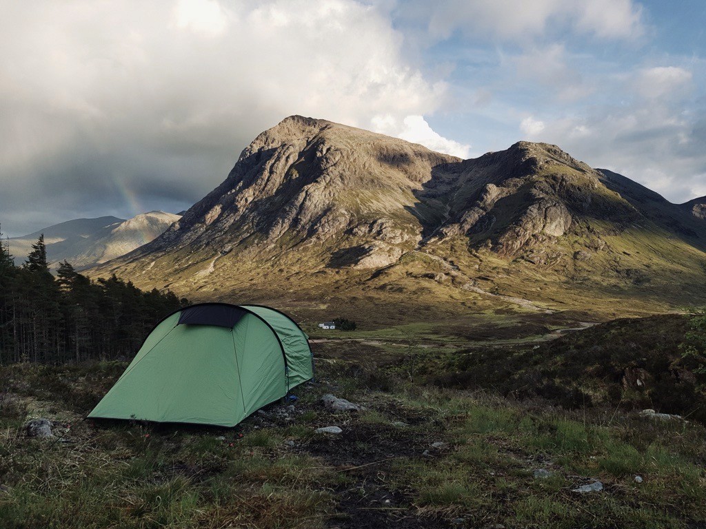 a tent pitched in front of a mountain