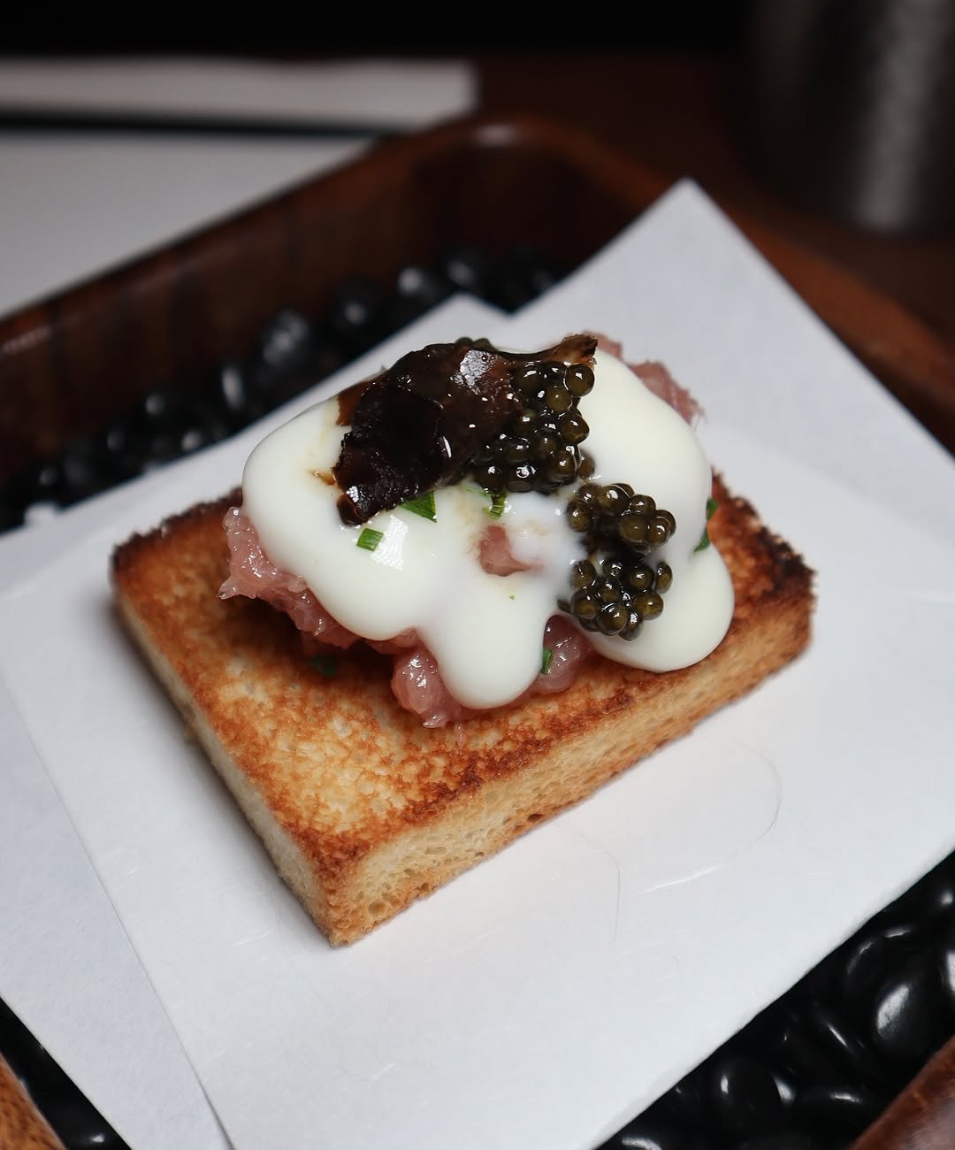 The signature Toro Tartare with Caviar at Toka Chef in NYC. A decadent dish served on crispy toast, topped with homemade yogurt sauce, caviar, and a touch of truffle for a luxurious finish.