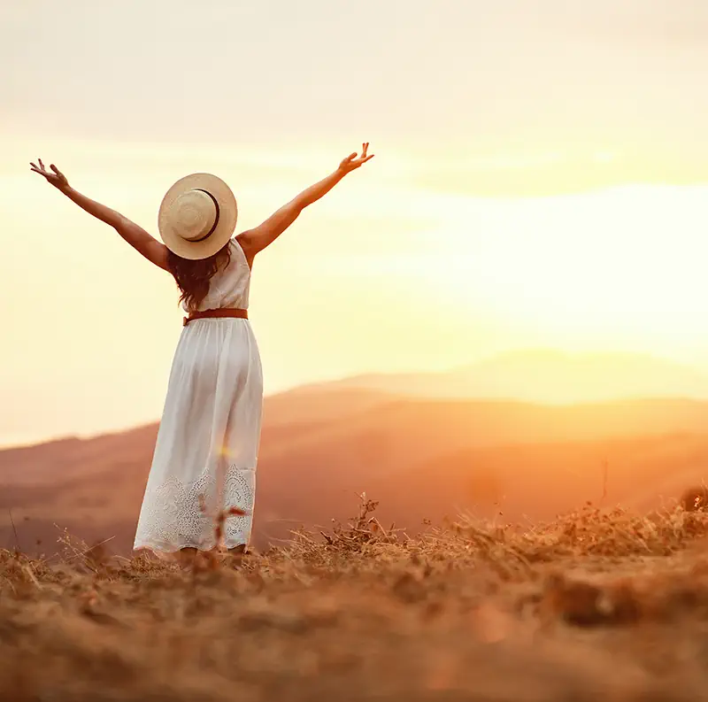 Woman celebrating at sunset, representing a fresh start