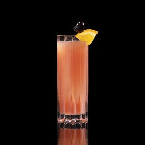 A closeup of a Sex on the Beach drink against a dark background.