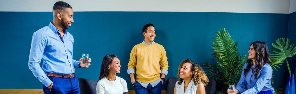 Diverse team in professional attire having a casual meeting.
